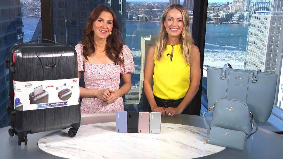Two women standing behind a table displaying a Luggage, Power Bank, Tote Set