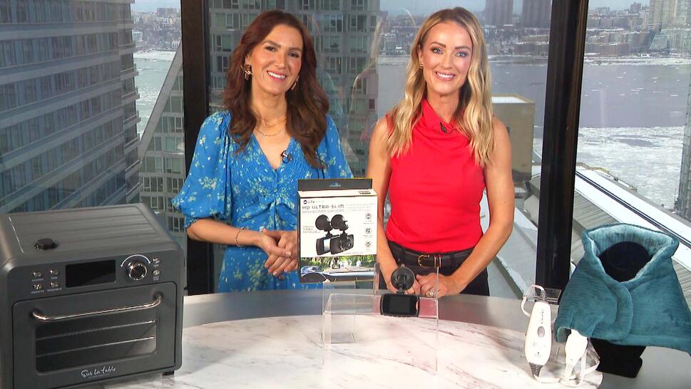 Two women standing behind a table displaying an Air Fryer, Dash Cam, Heating Pad
