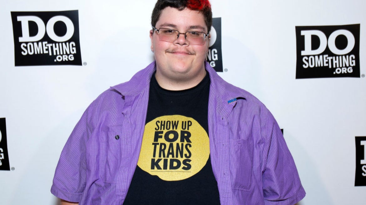 Gavin Grimm picture in front of a Do Something backdrop in a shirt that says Show Up For Trans Kids