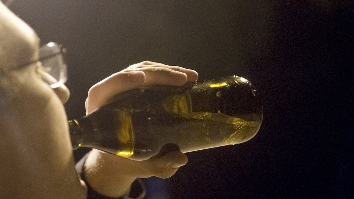 01 October 2021, Bavaria, Munich: A man drinks a bottle of beer in the evening.