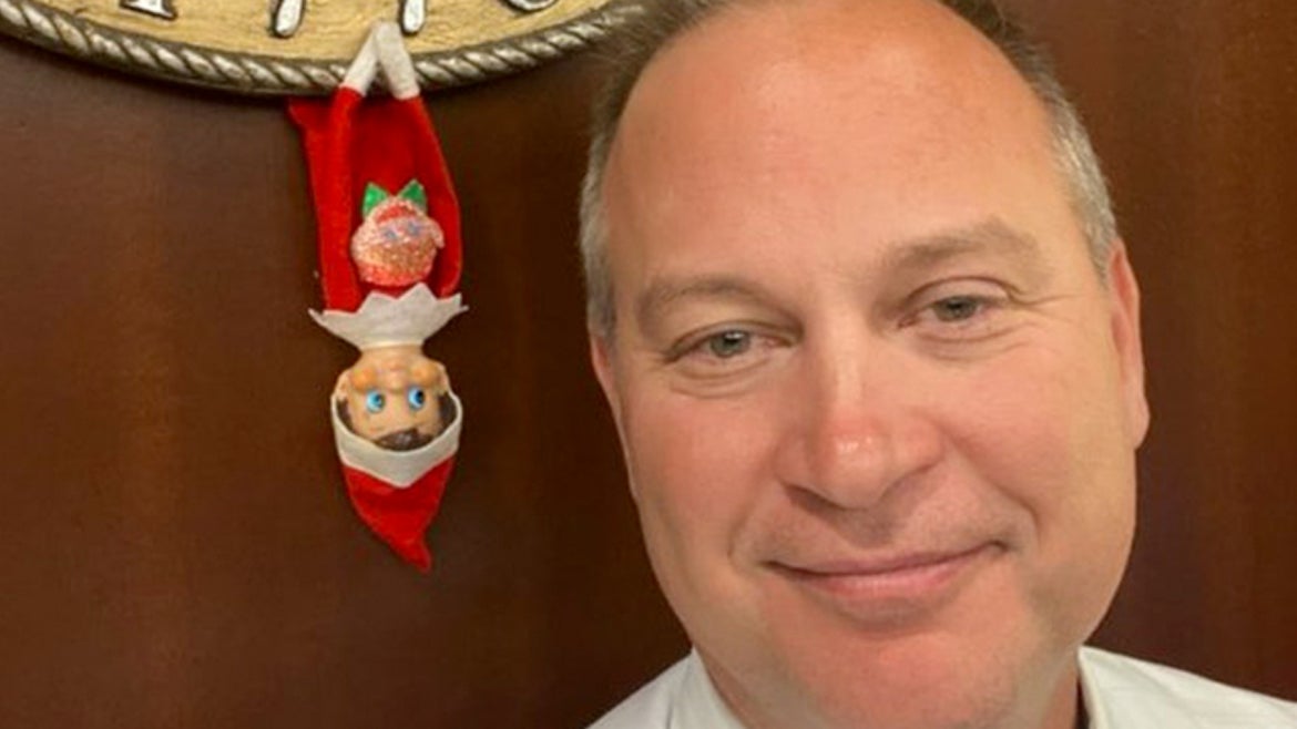 Judge Leonard pictured with an upside down "Elf on the Shelf"