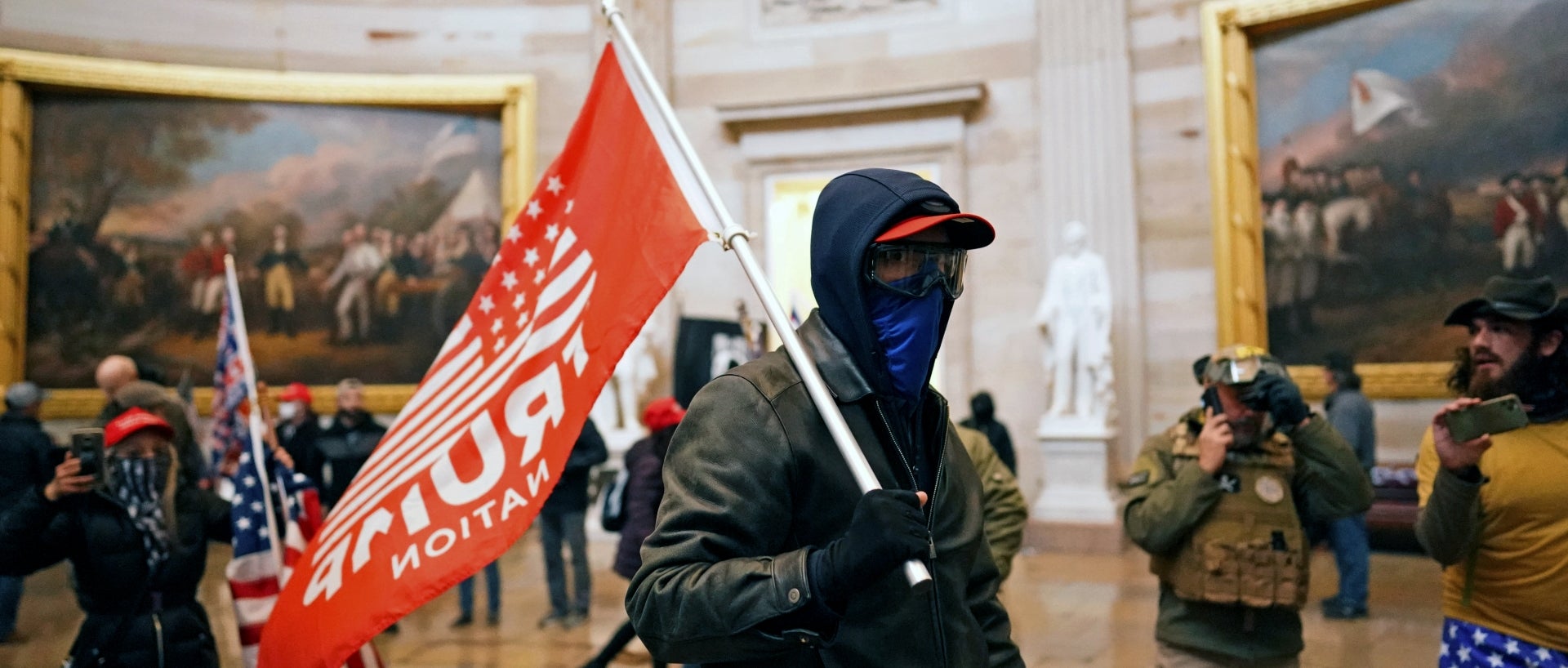 A rioter waves a "Trump Nation" flag inside the Capitol on Jan. 6, 2021.