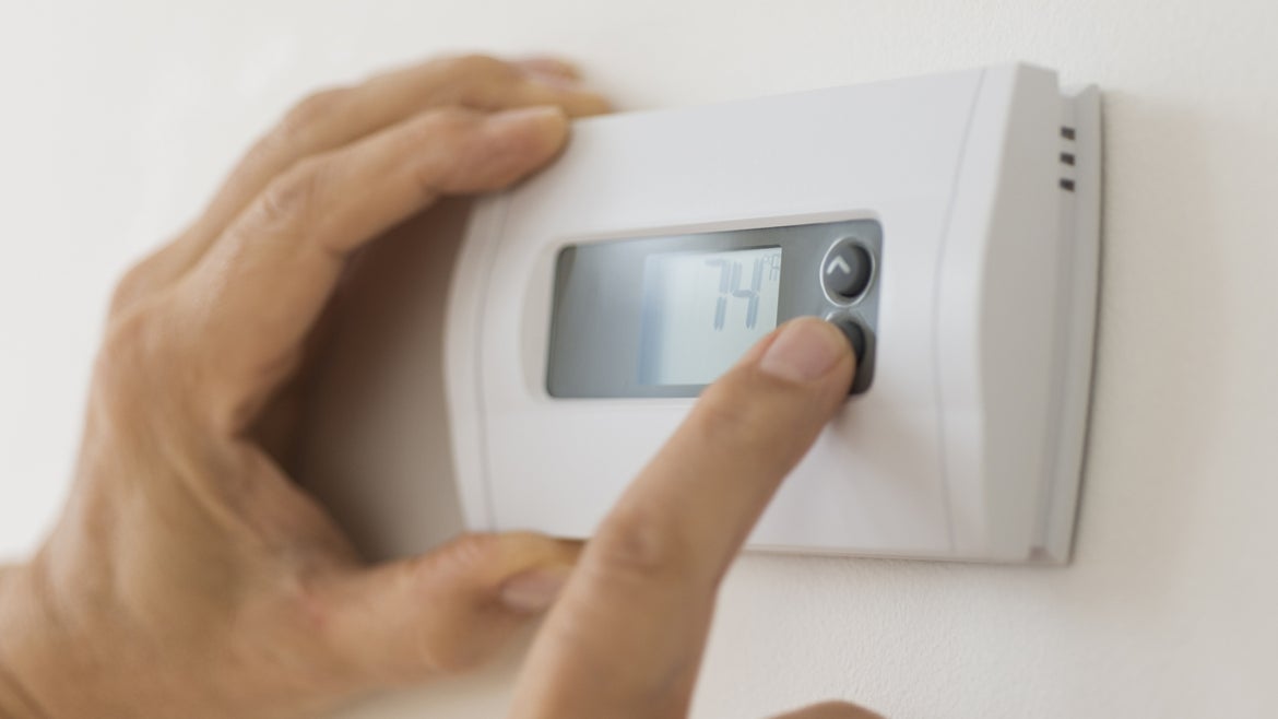 Hand on thermostat