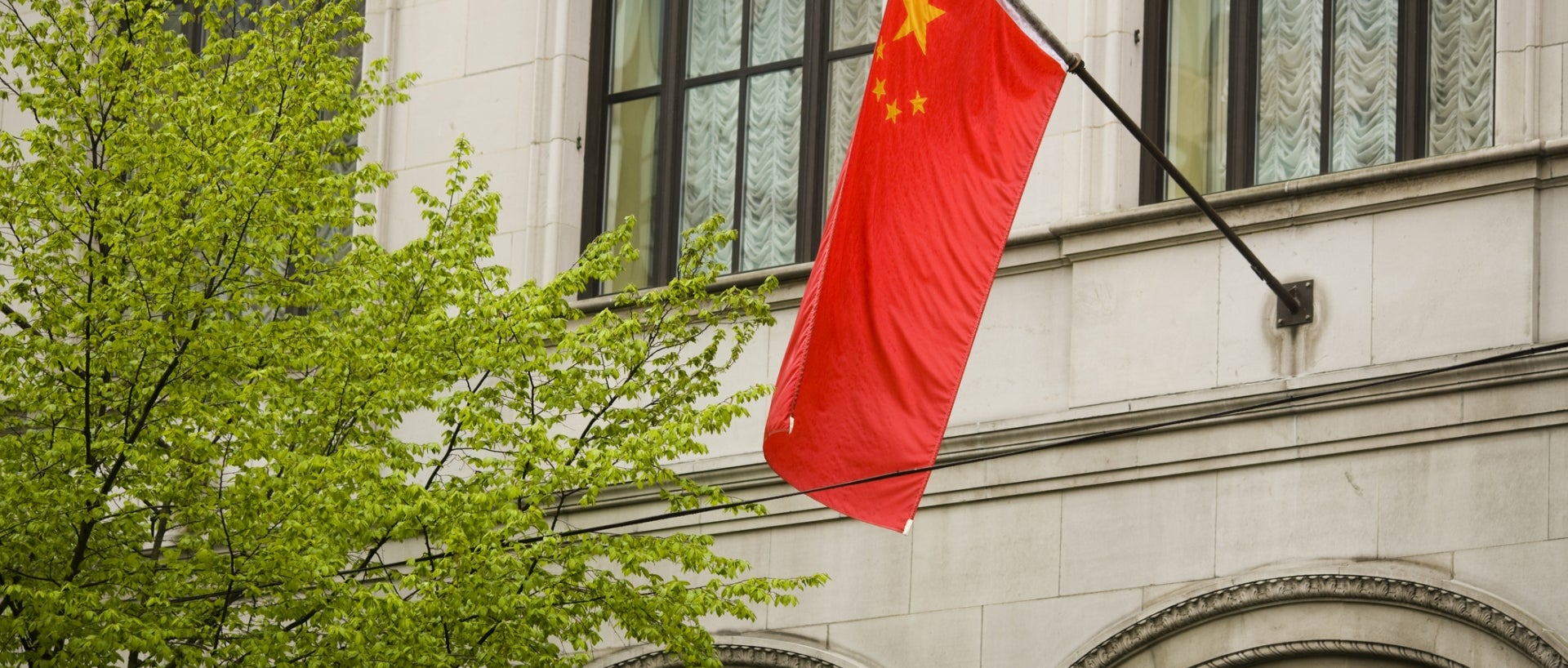 A Chinese flag hangs outside of a building.