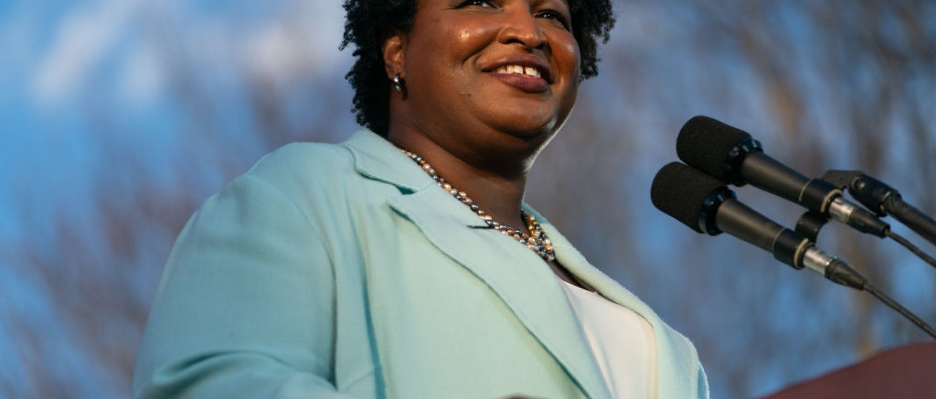 Stacey Abrams at a microphone smiling