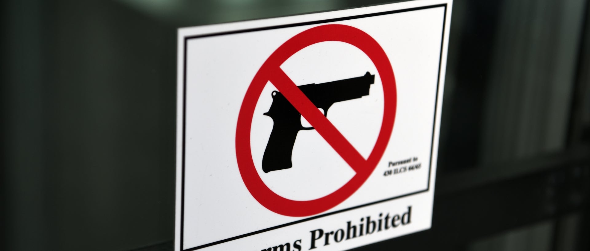Sign of a handgun crossed out reading 'firearms prohibited'
