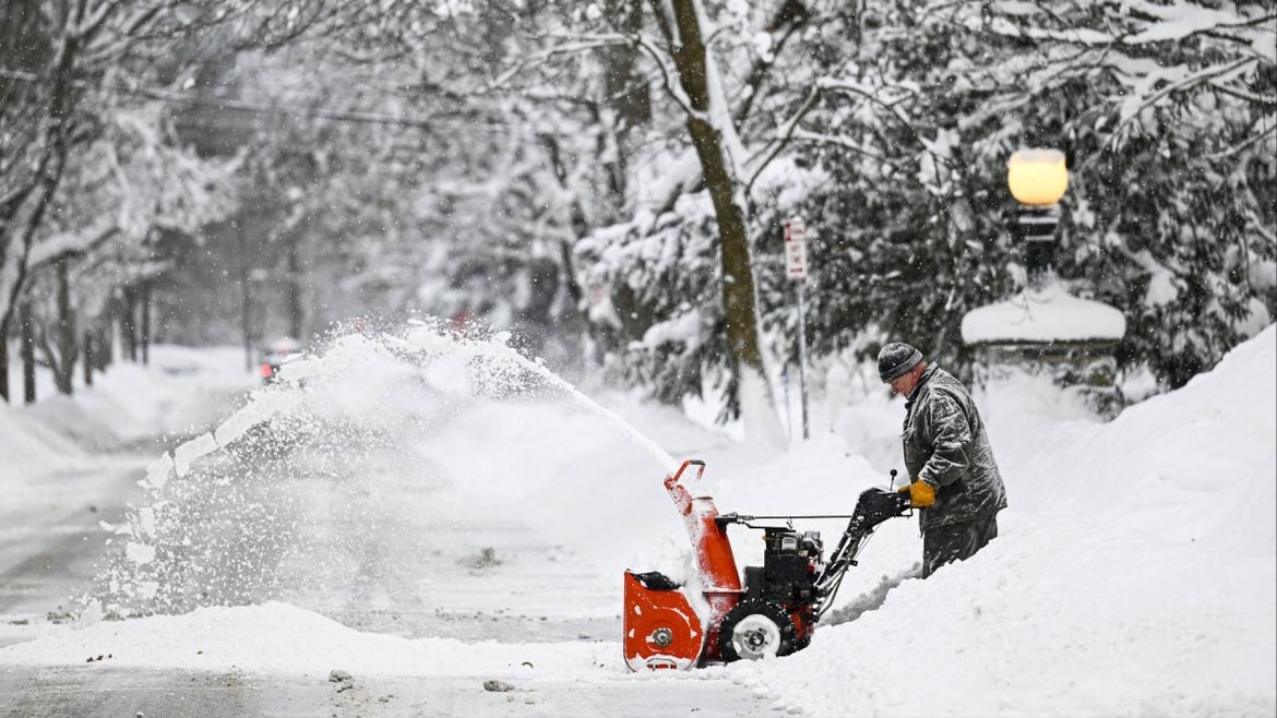 man pushing snow blower